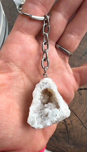 Angel aura quartz geode keyring shown in the hand for size