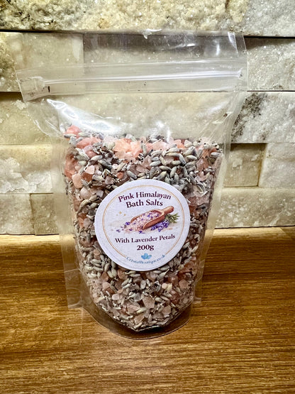 Bag of Pink Himalayan Bath Salts with Lavender Petals on a wooden surface