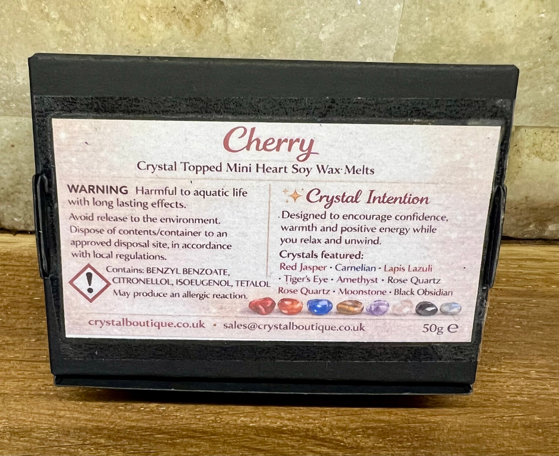 Crystal topped mini heart soy wax melts packaging with label on a wooden surface - cherry fragranced.