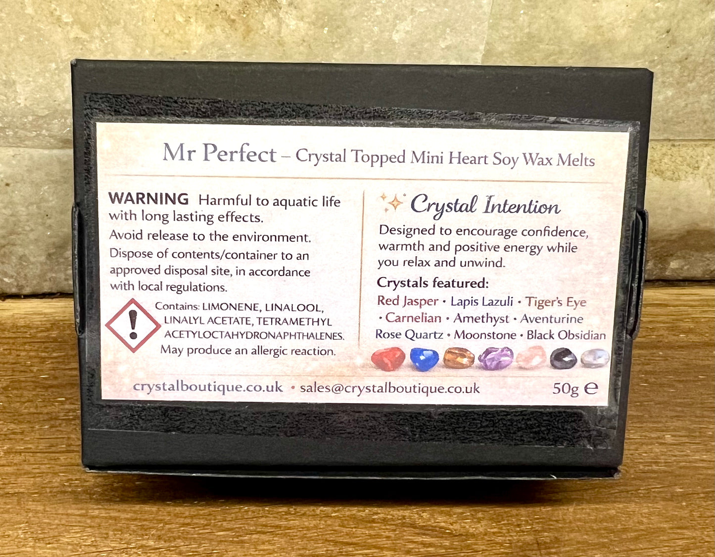 Box of Mr Perfect crystal topped mini heart soy wax melts with warning label on a wooden surface.