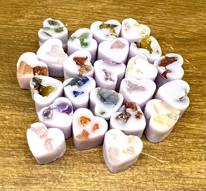 Heart-shaped soy wax melts with embedded crystal chips on a wooden surface