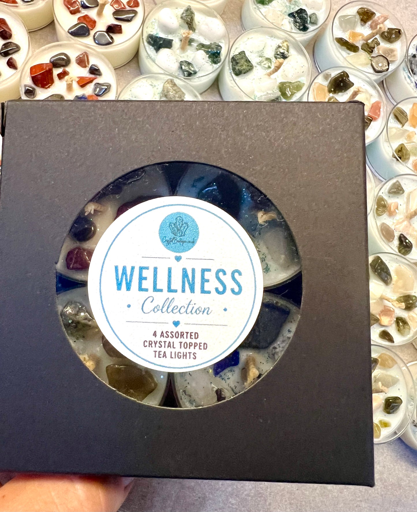 Box of Wellness Collection crystal-topped tea lights with a visible label.