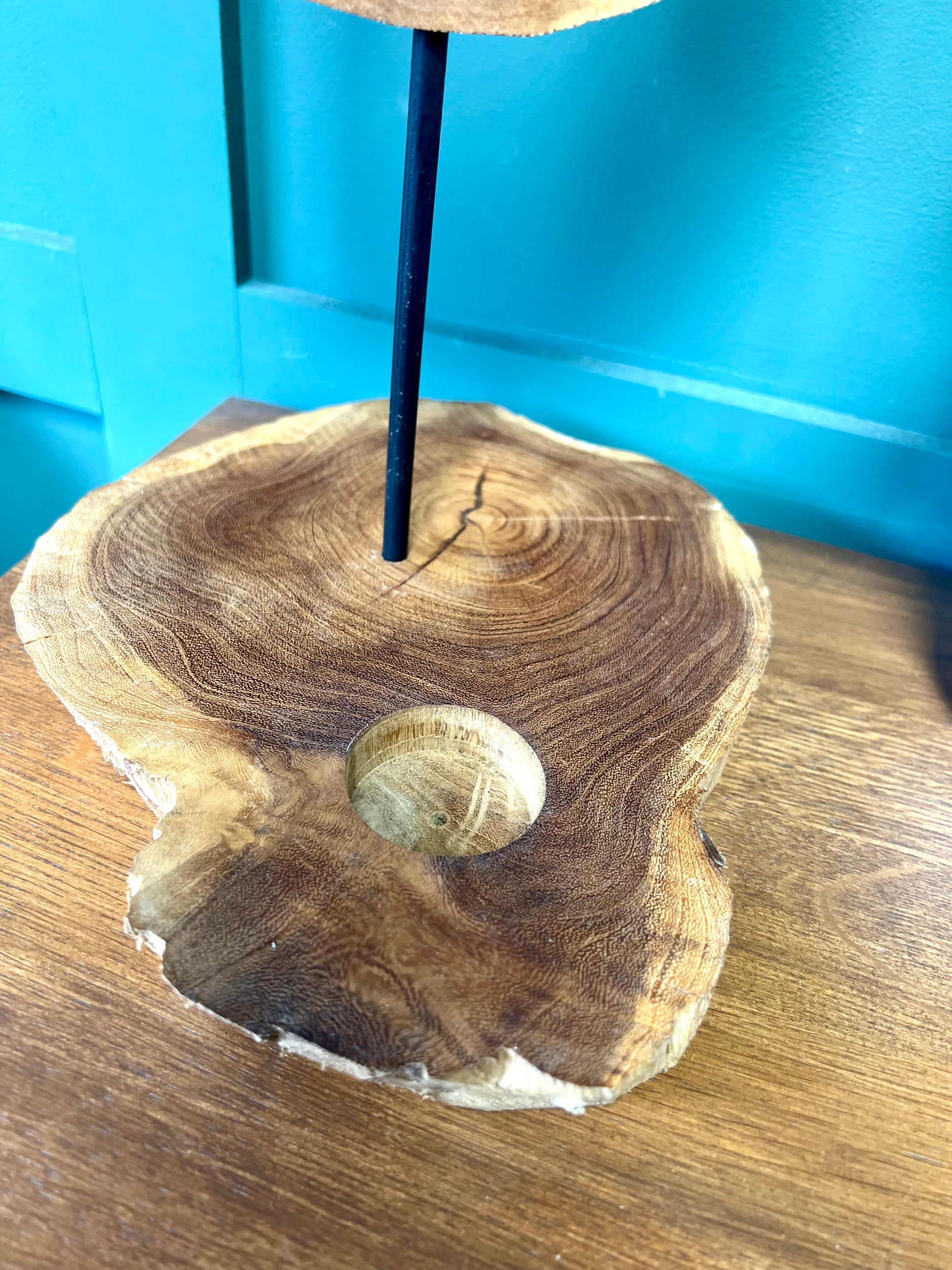 Wooden incense holder on a wooden surface with a blue wall in the background